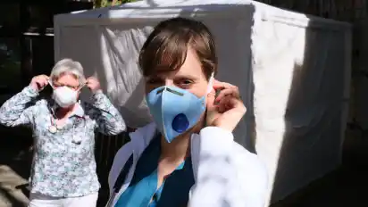 Die beiden Ärztinnen Barbara Pokies (links) und Anna Giegerich aus der Praxis Parkstraße in Hude demonstrieren hier vor dem Zelt für Infektionskrankheiten, wie sich die Gefahr von Neuansteckungen mit Schutzmasken leicht reduzieren lässt.