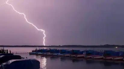 Ein Blitz entlädt sich in der Nacht hinter dem Tretbootsteg am Zwischenahner Meer.