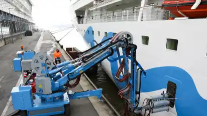 Ein Servicetechniker justiert den mobilen Kran (SAMS) der Landstromanlage am Cruise Center Altona mit einer Stromverbindung zu dem Kreuzfahrtschiff Aidasol.