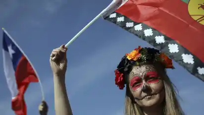 Eine Frau schwenkt in Santiago eine Flagge der indigenen Gemeinde der Mapuche während eines Protestes für Sozialreformen.
