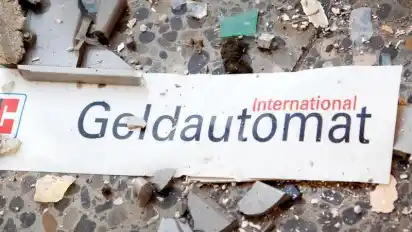 Splitter und ein abgerissenes Schild auf dem Fußboden vor einem gesprengten Geldautomaten. Foto: Patrick Pleul/dpa-Zentralbild/dpa