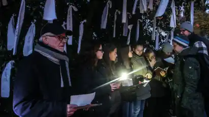 Schülerinnen der Oberschule Lesum verlasen unter Textilbändern mit den Namen der Opfer die Namen der Verstorbenen.