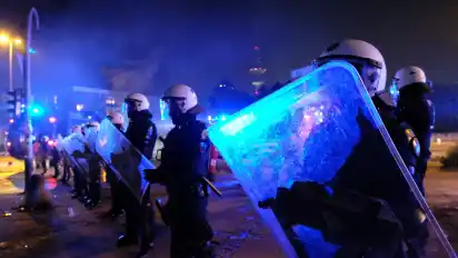 Polizisten mit Schutzschildern sichern während schwerer Ausschreitungen eine Zufahrtsstraße zum Schanzenviertel in Hamburg ab. Randalierer haben in dem Viertel eine Spur der Verwüstung hinterlassen. Zerstörte Fahrräder und Mülltonnen lagen auf der Straße. Fensterscheiben waren eingeschlagen oder beschädigt. Die Polizei hatte die Straße zuvor abgeriegelt und war massiv gegen die Randalierer vorgegangen.