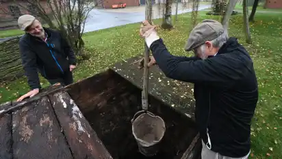 Wolfgang Dörfler holt mit Schwung Wasser aus dem wieder freigelegten Brunnen.