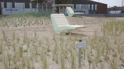 Neben dem Dünenbereich laden fest installierte Liegestühle zum Verweilen ein.