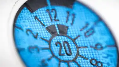 Plaketten-Uhr: Das fällige Jahr für die Hauptuntersuchung steht in der Mitte, der Monat stets oben. Die schwarzen Balken fungieren wie ein Stundenzeiger. Hier markieren sie bei «12 Uhr» den Monat Dezember. Ist die HU zum Beispiel aber im April fällig, steht oben eine «4» und die Balken markieren die «4-Uhr-Position». Foto: Alexander Heinl/dpa-tmn