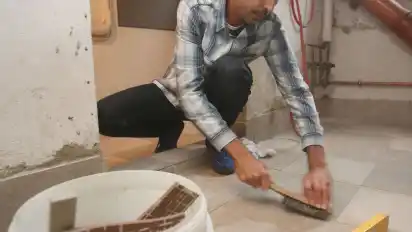 Ziad Karkour legt den Keller mit Fliesen aus.