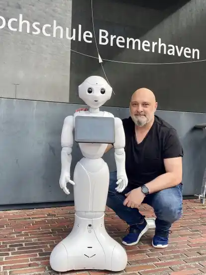 Alexis Papathanassis von der Hochschule Bremerhaven mit Roboter Pepper.