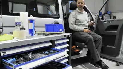 Dirk Poweleit zeigt, wie ein sogenanntes Schwenksitzsystem seinen Nutzer mithilfe einer Fernbedienung aus dem Fahrzeug heraus und wieder hinein manövrieren kann.