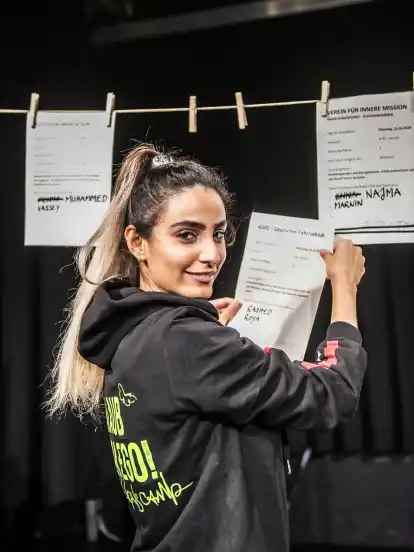 Die 23-jährige Roya Rasuli schaut sich im Volkshaus die Projektbeschreibungen genauer an. Die Jugendlichen konnten sich täglich eine „Herzaktion“ heraussuchen.