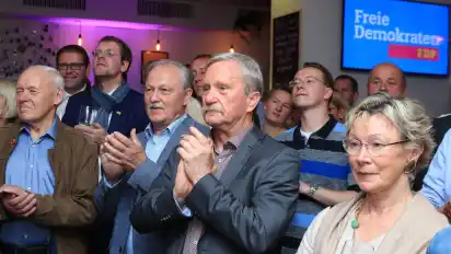 Die Mitglieder des erweiterten Landesvorstandes Rainer Buchholz (Mitte) und Peter Zenner (rechts) freuen sich über das Bundesergebnis der Liberalen. Im Hintergrund versucht der stellvertretende Landesvorsitzende Magnus Buhlert einen Blick auf die Hochrechnung zu erhaschen.