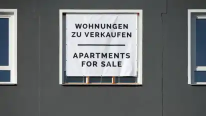 Mit einem großen Plakat werden Wohnungen zum Kauf angeboten. Weniger Maklerkosten entlasten Immobilienkäufer vor allem in Städten, wo Häuser und Wohnungen sehr teuer sind. Foto: Andrea Warnecke/dpa