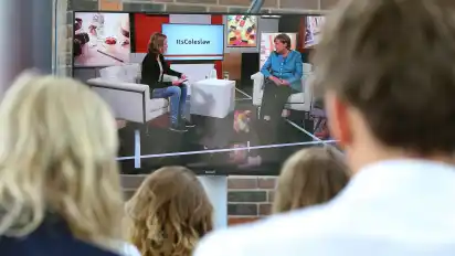 Zuschauer verfolgen in einem Nebenraum wie Bundeskanzlerin Angela Merkel (CDU) von YouTubern und der Online-Community in einem Livestream interviewt wird.
