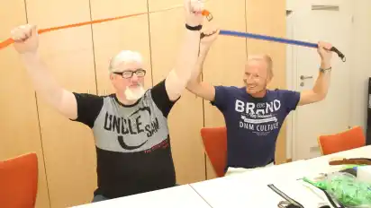 Peter Fuhs (links) lässt sich von Jürgen Weemeyer die Gymnastik mit Gürteln zeigen.