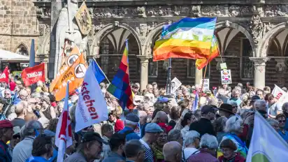 Friedensfahnen wehen auf dem Bremer Marktplatz: Zur Abschlusskundgebung des Ostermarsches haben sich am Sonnabend mehrere Hundert Menschen versammelt.