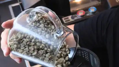 Der grüne Rohkaffee kommt in die Trommel der Röstmaschine. Bei mehr als 200 Grad wird er langsam braun.