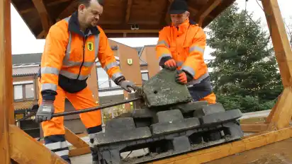 „Xaver“ kann kommen: Heiner Wessel (links) und Ingo Husmann beschweren den Pavillon in der Mitte des Weihnachtsmarktes auf dem Syker Rathausvorplatz.