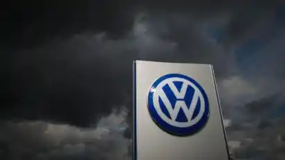 Dunkle Wolken ziehen über ein Logo des Autobauers am VW-Werk in Wolfsburg. Foto: Julian Stratenschulte