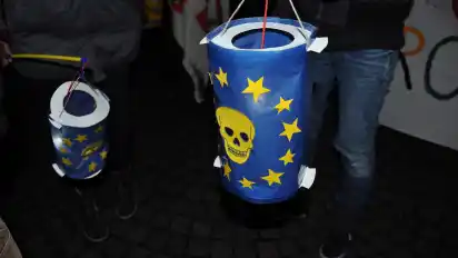 Mit Laternen und Plakaten demonstrieren die Aktivisten gegen die EU als Friedensnobelpreisträger.