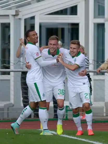 Levent Aycicek (r.) lässt sich im Spiel gegen Oldenburg von seinen Werder-Teamkollegen Leon Guwara (l.) und Max Wegner (M.) feiern.