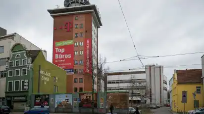 Der Telekom-Turm markiert das gleichnamige Gelände. Davor und drumherum herrscht Tristesse. In bester Lage parken Autos auf Schotterplätzen.