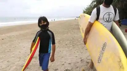 Auch Surfer gibt es in dieser Saison nur wenige auf Bali. Die Corona-Pandemie trifft die Urlaubsinsel besonders hart. Foto: Firdia Lisnawati/AP/dpa