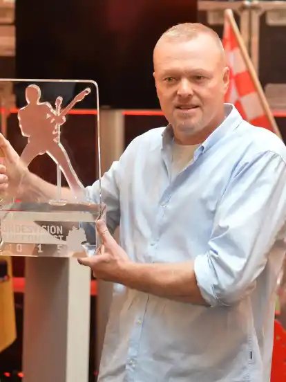 Moderator Stefan Raab zeigt die Trophäe des Bundesvision Song Contest.