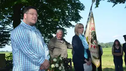 Umrahmt von Fahnenträgern des Heimatvereins und der Klootschießer gedenken Andreas Wienholz (links) und Regina Neuke am St.-Veit-Denkmal den Stedingern und ihrem Freiheitskampf. HJO·