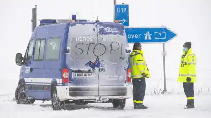 Helfer vom Technisches Hilfswerk THW stehen an der gesperrten Zufahrt zur Autobahn A7. Die Polizei hat die A7 wegen Schneeverwehungen und schlechter Sicht aufgrund des Schneesturms in Fahrtrichtung Norden zwischen Bockenem und dem Dreieck Salzgitter gesperrt.