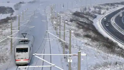 Eisige Zeiten in Thüringen: Ein ICE fährt bei Arnstadt auf der Strecke zwischen Berlin und München entlang der Autobahn A71. Foto: Martin Schutt/dpa-Zentralbild/dpa