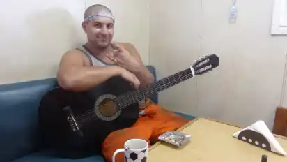 Der Schlosser Kostya Vakulenko sitzt im Raucherraum mit der Gitarre in der Hand. Irgendjemand hat immer mal Gitarre gespielt und durchaus passabel gesungen.