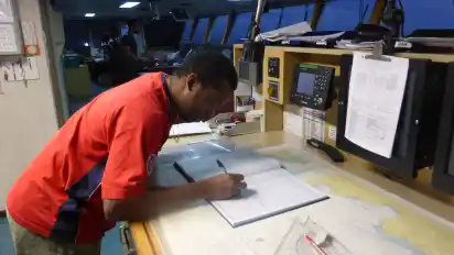 Der Erste Offizier, Jovan Weir, macht Eintragungen im Logbuch. Hier am Tisch schauen die Offiziere auch auf die Karten für den Kurs.