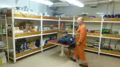 Bootsmann (auch Bosun genannt) Oleks Matyushynets im Trockenlager des Schiffs. Hier stehen alle möglichen Lebensmittel wie Zucker oder Marmelade, die nicht gekühlt werden müssen. Die Lebensmittel stammen zum Großteil aus Deutschland.