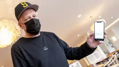 Rapper Smudo demonstriert auf seinem Smartphone die Funktionsweise der App Luca.