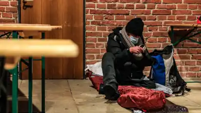 Markus richtet sich für die Nacht zwischen den aufgestellten Tischen in der Kirche Unser Lieben Frauen ein.