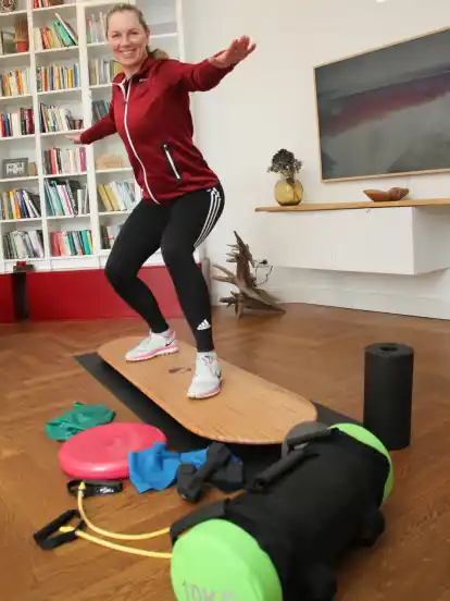 Gar nicht so einfach: Auf einem wackeligen Balanceboard das Gleichgewicht halten. Die Fachtrainerin für Senioren Yvonne Plaster besucht ältere Menschen zu Hause, um mit ihnen Beweglichkeit, Balance und Reflexe für mehr Mobilität im Alltag zu trainieren.