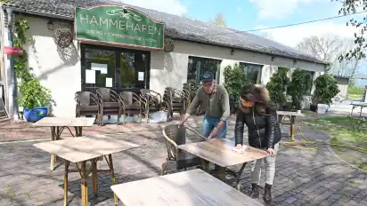 Ralf Soujon und Mitarbeiterin Tatjana Virchow räumen die Terrasse des Bistros am Hammehafen in Worpswede auf.
