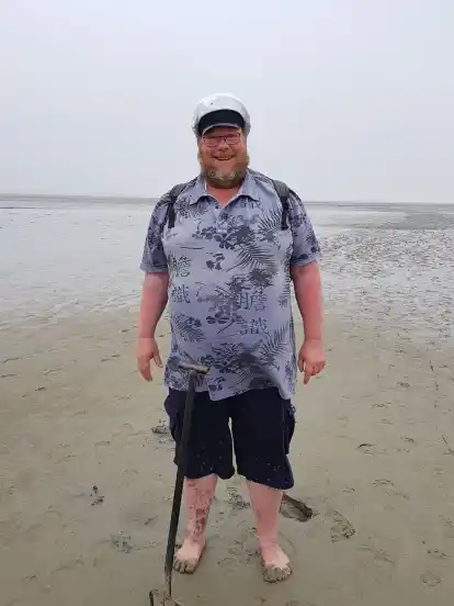 Wattführer Albertus Akkermann lässt seine Gäste bei der Wanderung Strandbeifuß probieren und Wattwürmer ausgraben.
