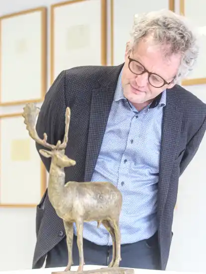 Arie Hartog, Direktor des Gerhard-Marcks-Hauses, betrachtet eine Hirschskulptur des Künstlers.