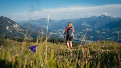 Christina Foidl blickt in die Bergkulisse der Kitzbüheler Alpen.