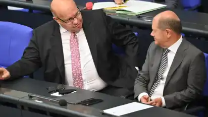 Bundesfinanzminister Olaf Scholz (SPD, r) spricht mit Bundeswirtschaftsminister Peter Altmaier (CDU) bei einer Sondersitzung des Deutschen Bundestages. Foto: Bernd Von Jutrczenka/dpa