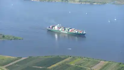 Ein Containerschiff der Reederei Evergreen ist auf der Elbe unterwegs. Damit der internationale Schiffsverkehr auf Elbe und Weser sicher bleibt, verlangen die Grünen, Lehren aus der Havarie der "Ever Given" zu ziehen.