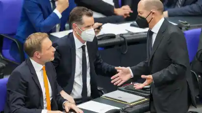Christian Dürr (Mitte) im Gespräch im Bundestag mit seinem Amtsvorgänger Christian Lindner (links) und dem designierten Kanzler Olaf Scholz.