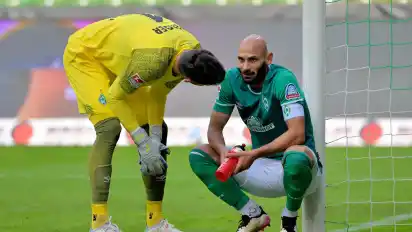 Und wieder hat er einen abbekommen: Werders Torwart Jiri Pavlenka erkundigt sich bei Ömer Toprak, wie stark die Schmerzen sind.
