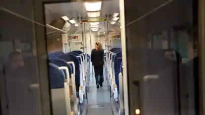 Eine Schaffnerin geht durch einen Regionalzug.