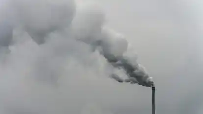 Qualm steigt aus dem Schornstein einer Fabrik.