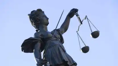 Eine Statue der Justitia steht unter freiem Himmel.