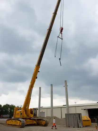 Per Kran werden die tonnenschweren Betonpfeiler angehoben.