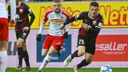 Der Regensburger Jan-Niklas Beste (l) und Florian Pick vom FC Ingolstadt kämpfen um den Ball.