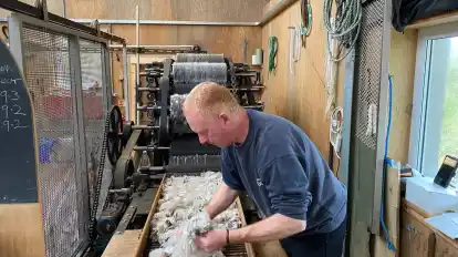 Ein Mann arbeitet in der Fabrik Uist Wool in Grimsay.